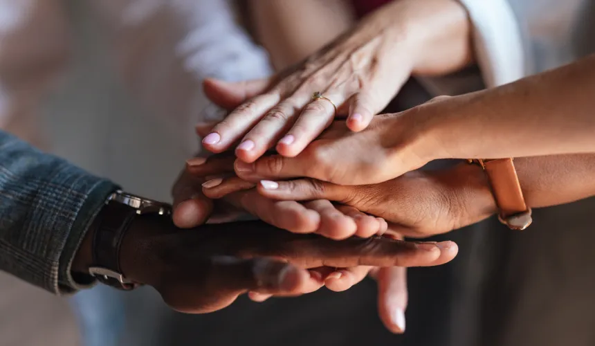 Diverse hands stacked together in unity