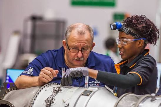 Trainer and young technician working together on equipment